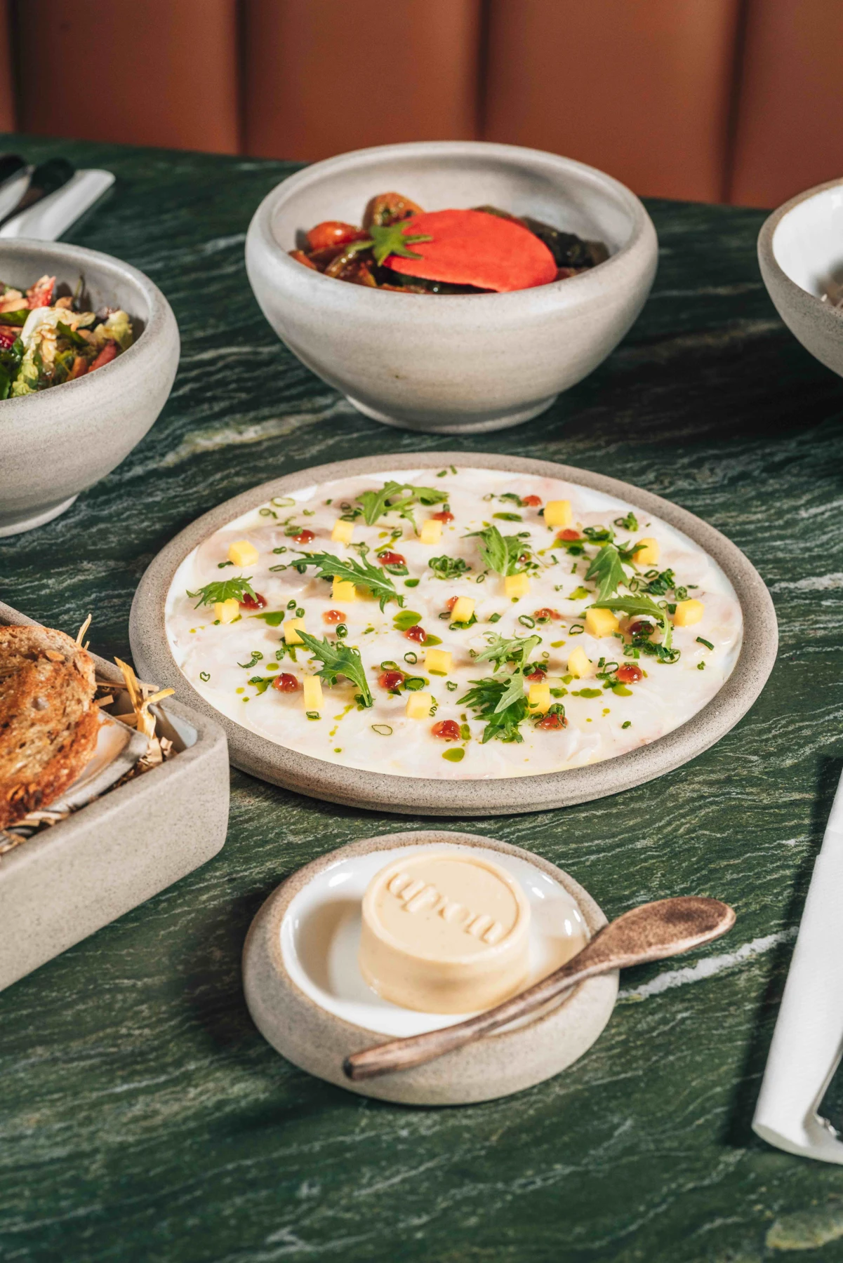 A selection of UPON Paphos dishes served on a green marble table